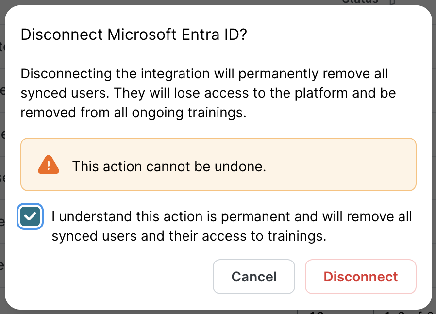 Disconnect Microsoft Entra ID confirmation dialog. Heading: Disconnect Microsoft Entra ID? Warning text: Disconnecting will permanently remove all synced users and they will lose access to platform and trainings. Orange warning banner stating This action cannot be undone. Checkbox to confirm and red Disconnect button.